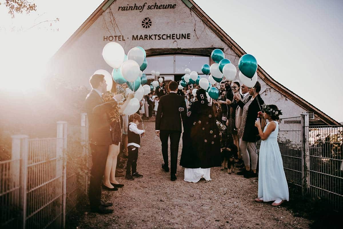 Das Hochzeitspaar mit Hochzeitsgästen und vielen Luftballons.