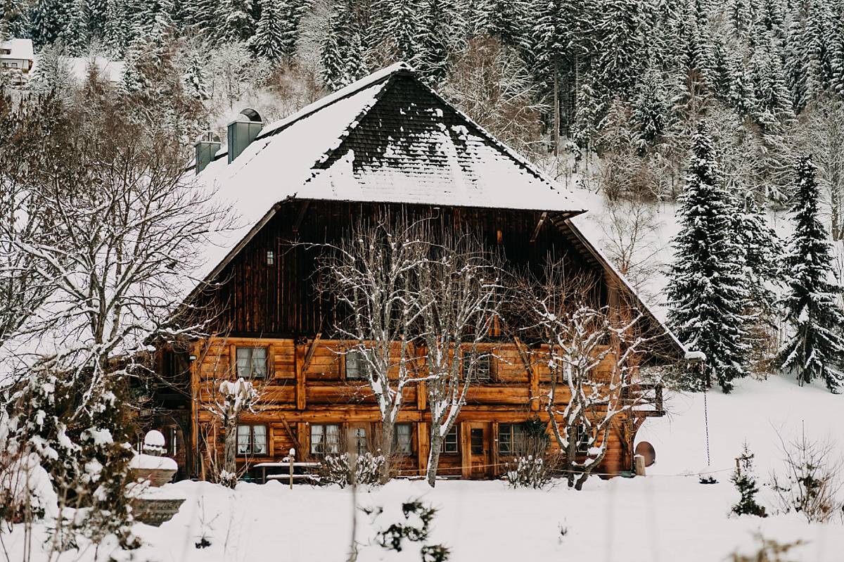 Eine mit Schnee bedeckte Holzhütte.