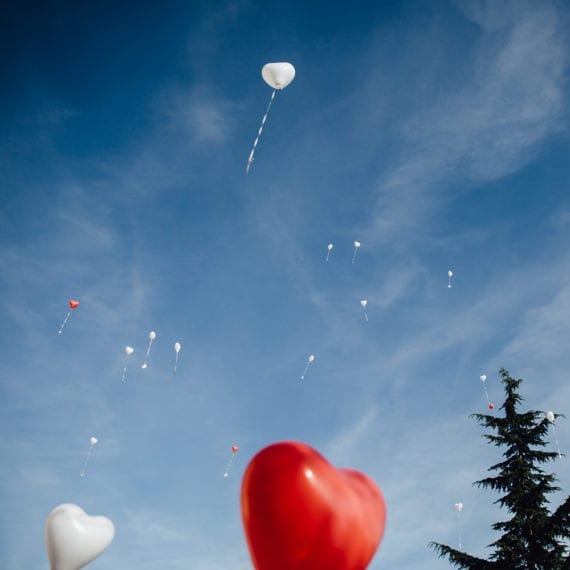 Herzförmige Luftballons steigen in die Luft empor.