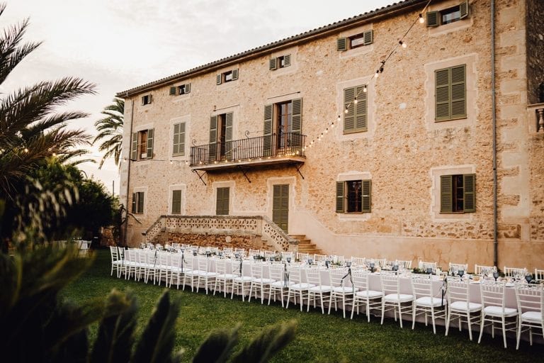 Finca auf Mallorca, geschmückt mit einer Lichterkette, davor Chiavari Stühle.