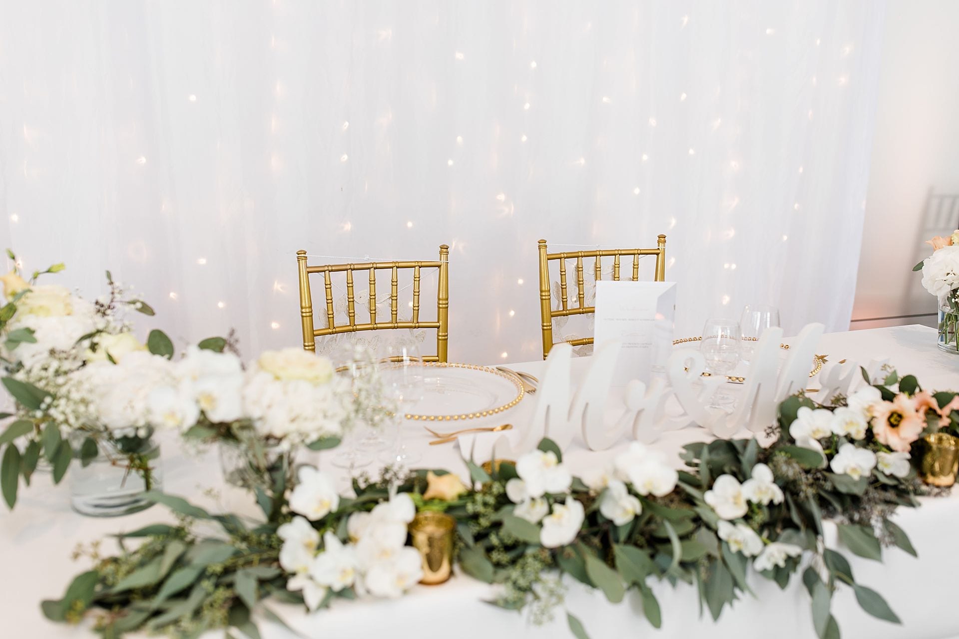 Tischdeko mit Blumen und goldenen Stühlen