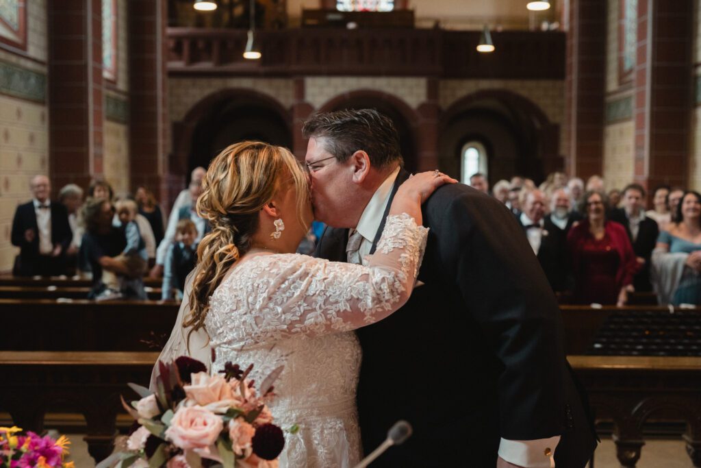 Braut paar küsst sich bei der Trauung in der Kirche in Hinterzarten